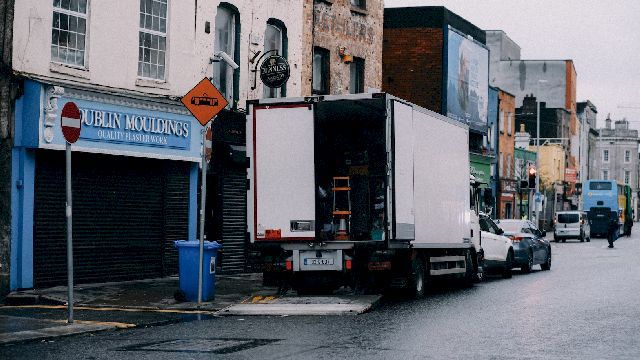 Photo of a truck being loaded outside a shop.