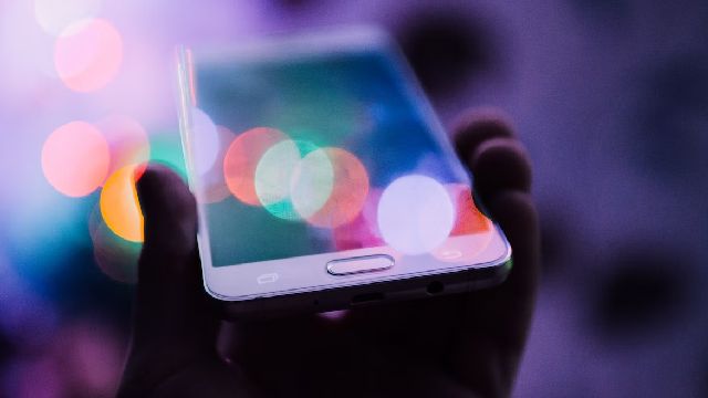 Image of a hand holding a smartphone in the light.