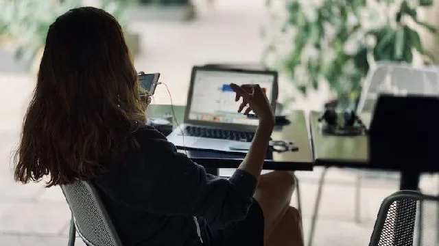 Image of a woman communicating on a phone oustide.