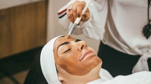 Photo of a woman receiving a face mask.