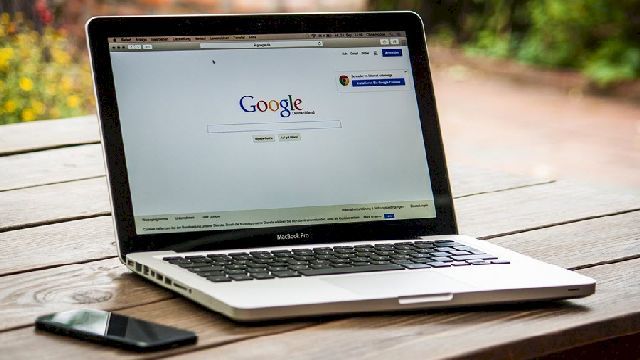 Photo of a laptop displaying Google's homepage in Chrome browser.