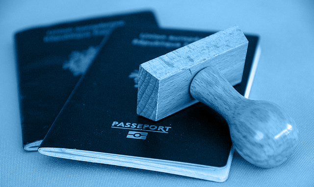 Image of a stamp lying atop two passports.